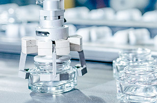 Chaîne de production de flacons de parfum, visuel illustrant le pilier "Produire durablement" du programme "Sharing Beauty With All".